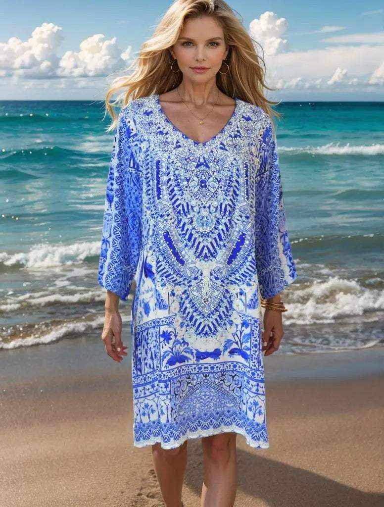 Woman wearing peacock silk hand beaded tunic dress with 3/4 sleeves and V-neck on the beach